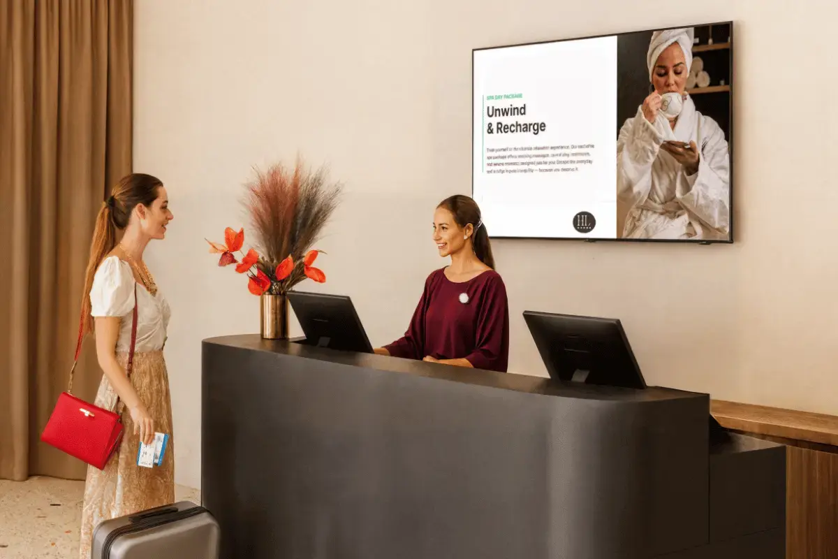 Two females in a lobby with digital signage