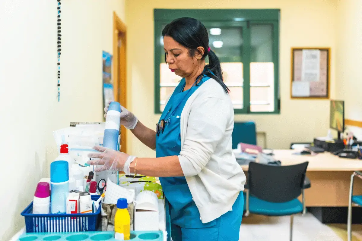 A female nurse working in a senior facility with various cleaning supplies