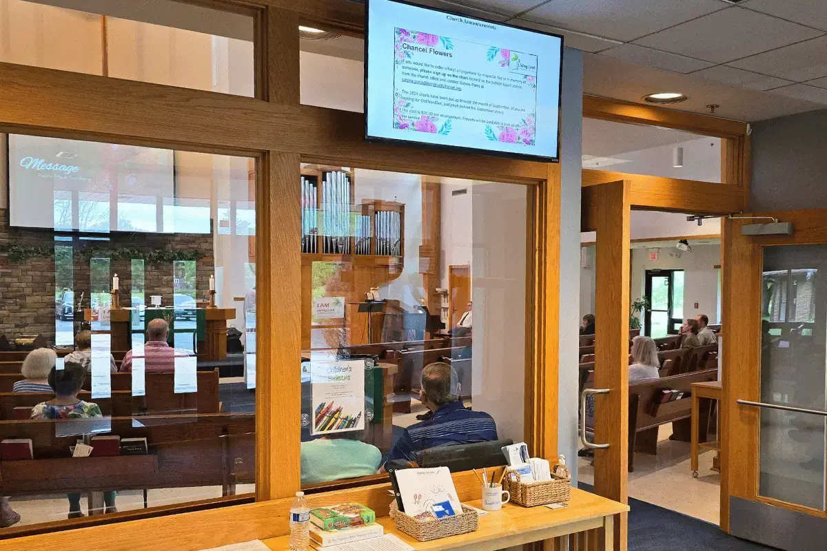 A dsmall digital display on top of a congregation gathering entrance