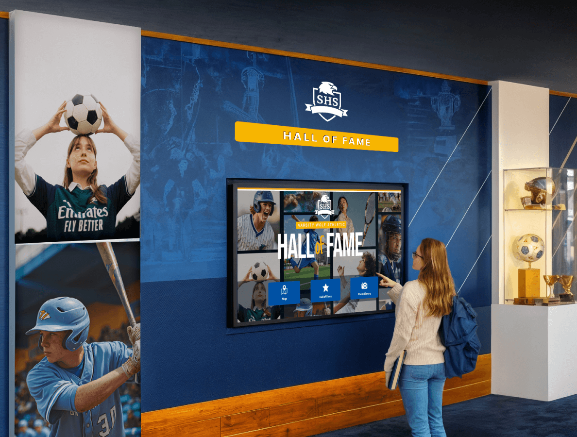 A female high school student interacting with a digital hall of fame display