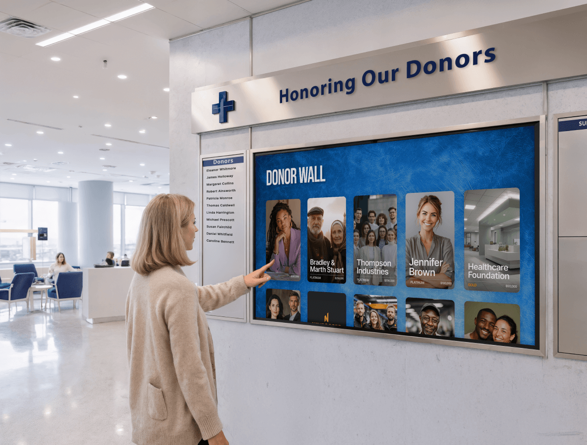 Middle aged woman tapping on a hospital donor wall digital display