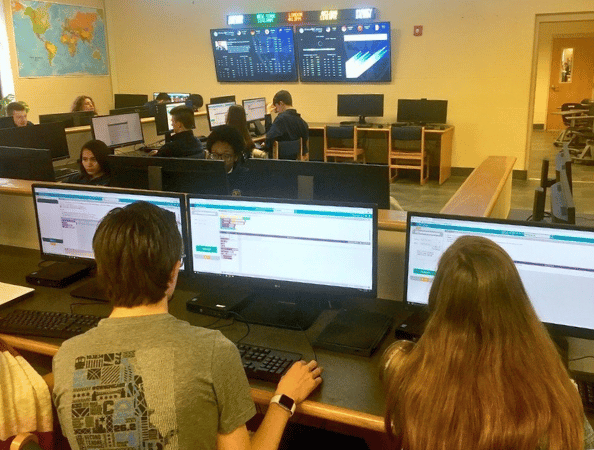 Screen sharing technology with students sitting at their lab desks using large displays