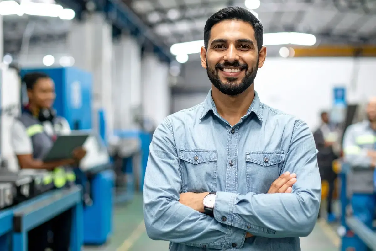 Male standing in front of a camera in a manufacturing facility