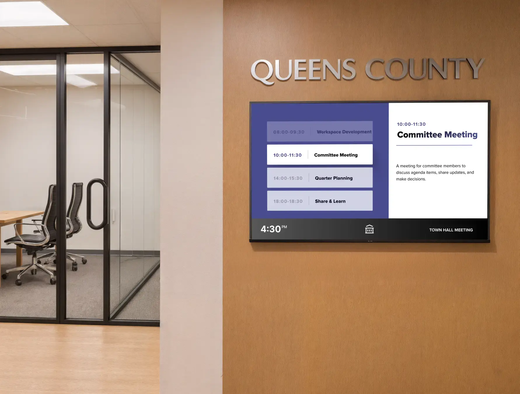Qeens County digital signage on a wall near a conference room