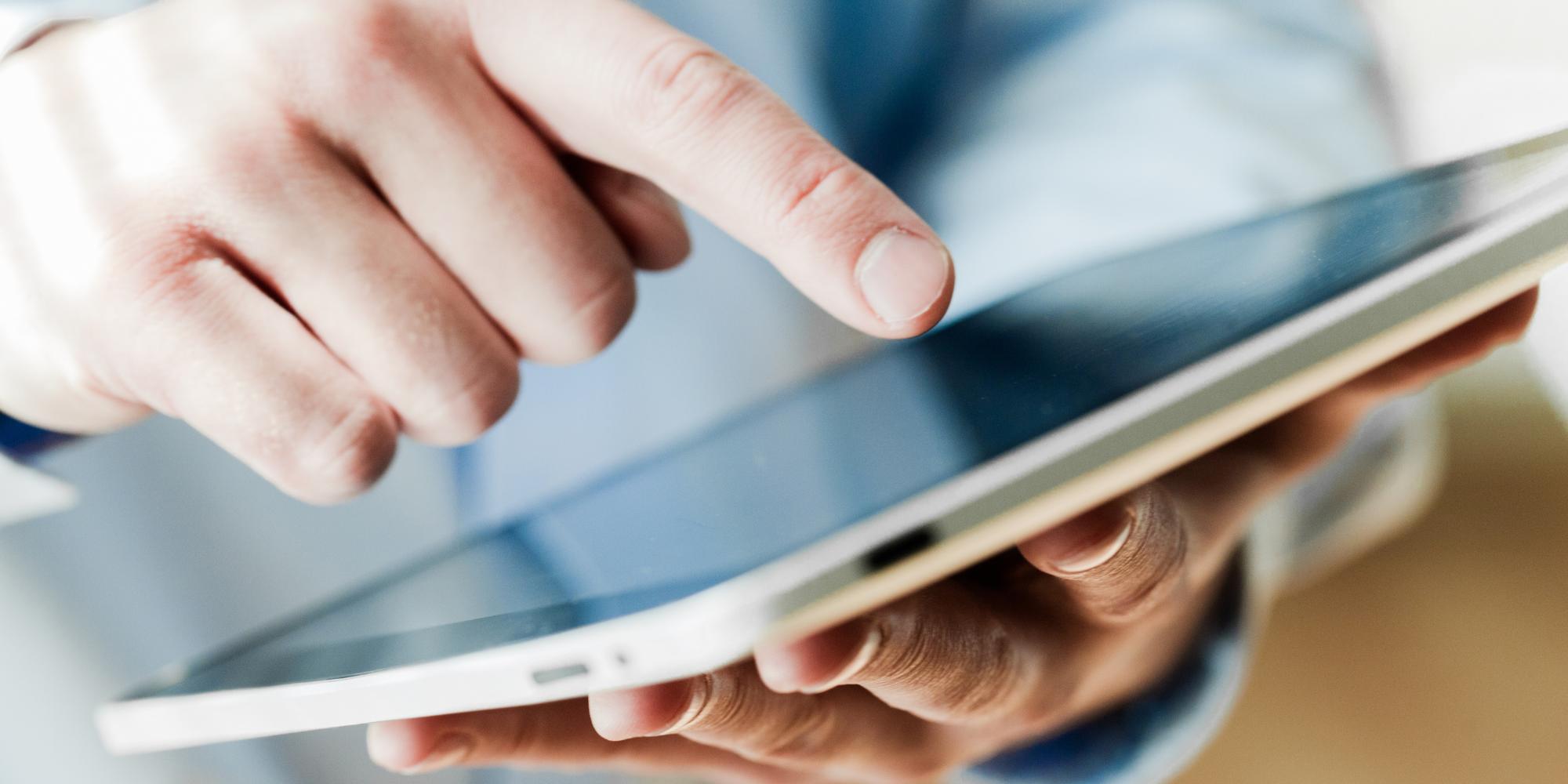 A man using a digital signage content management system from a tablet.