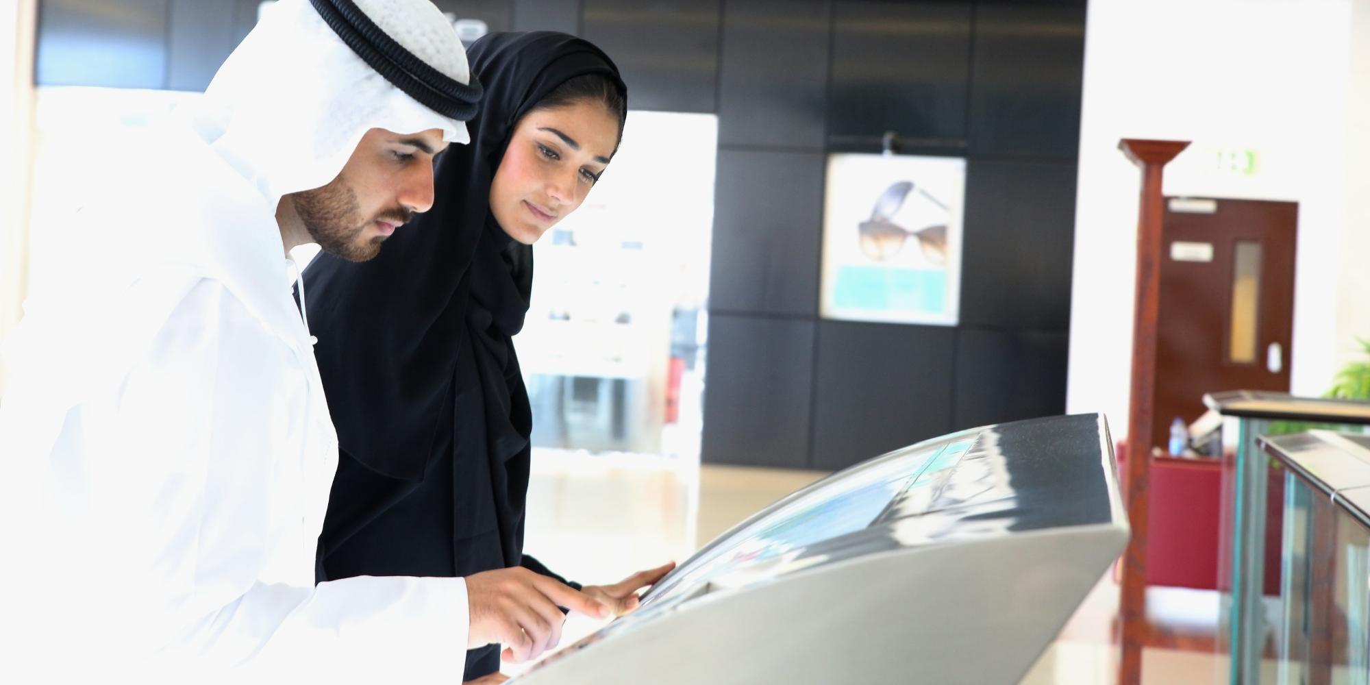 A couple touching an interactive digital sign.