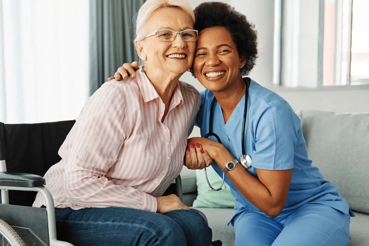 A senior and her nurse hugging and smiling