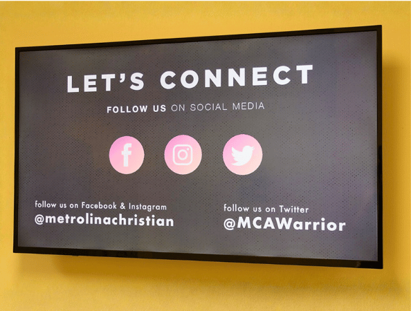 A digital display showing a school's social media account handles
