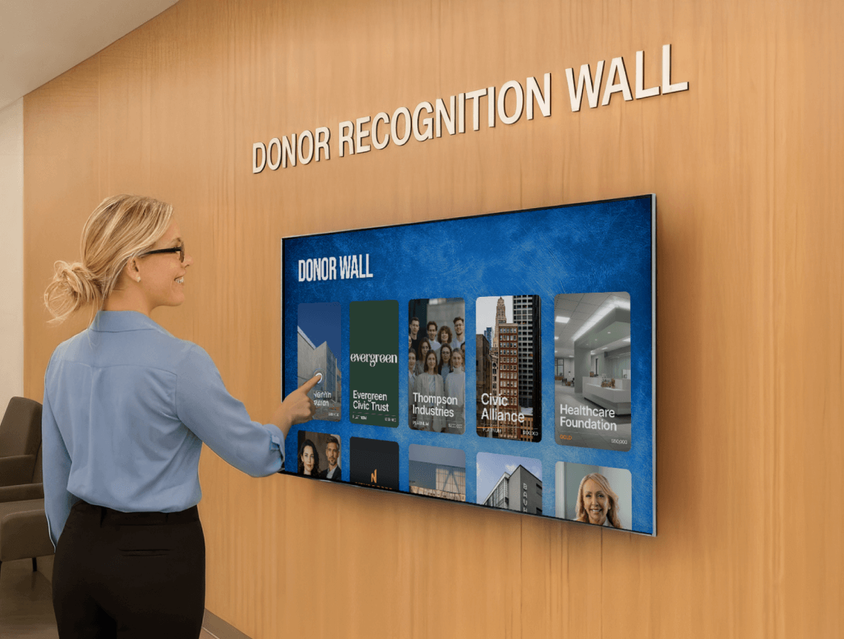 A female office worker interacting with a donor recognition wall