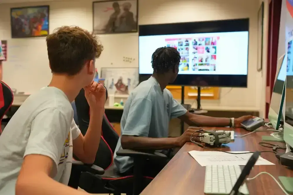 Two young men viewing a Rise Vision digital signage display in a classroom setting