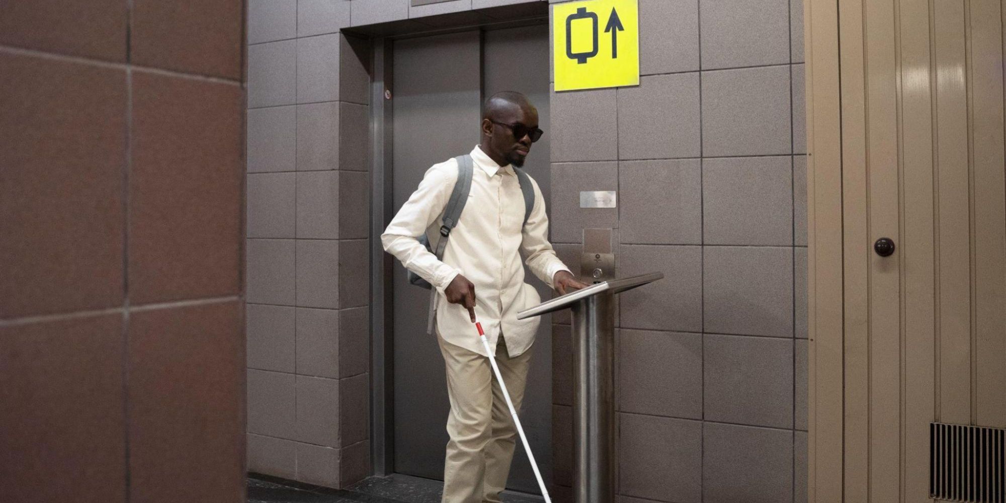 A blind man navigating a digital signage installation.