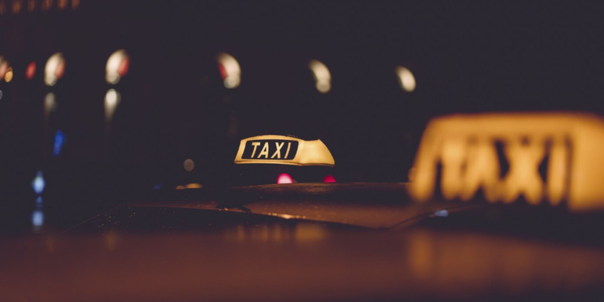 An illuminated sign on top of a taxi cab.