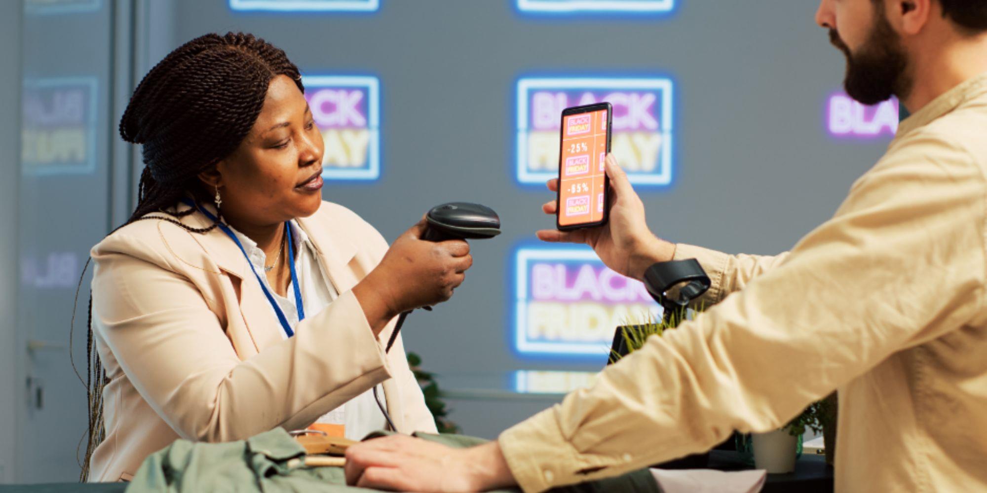  A lady behind a register scanning a QR code of digital signage loyalty program.