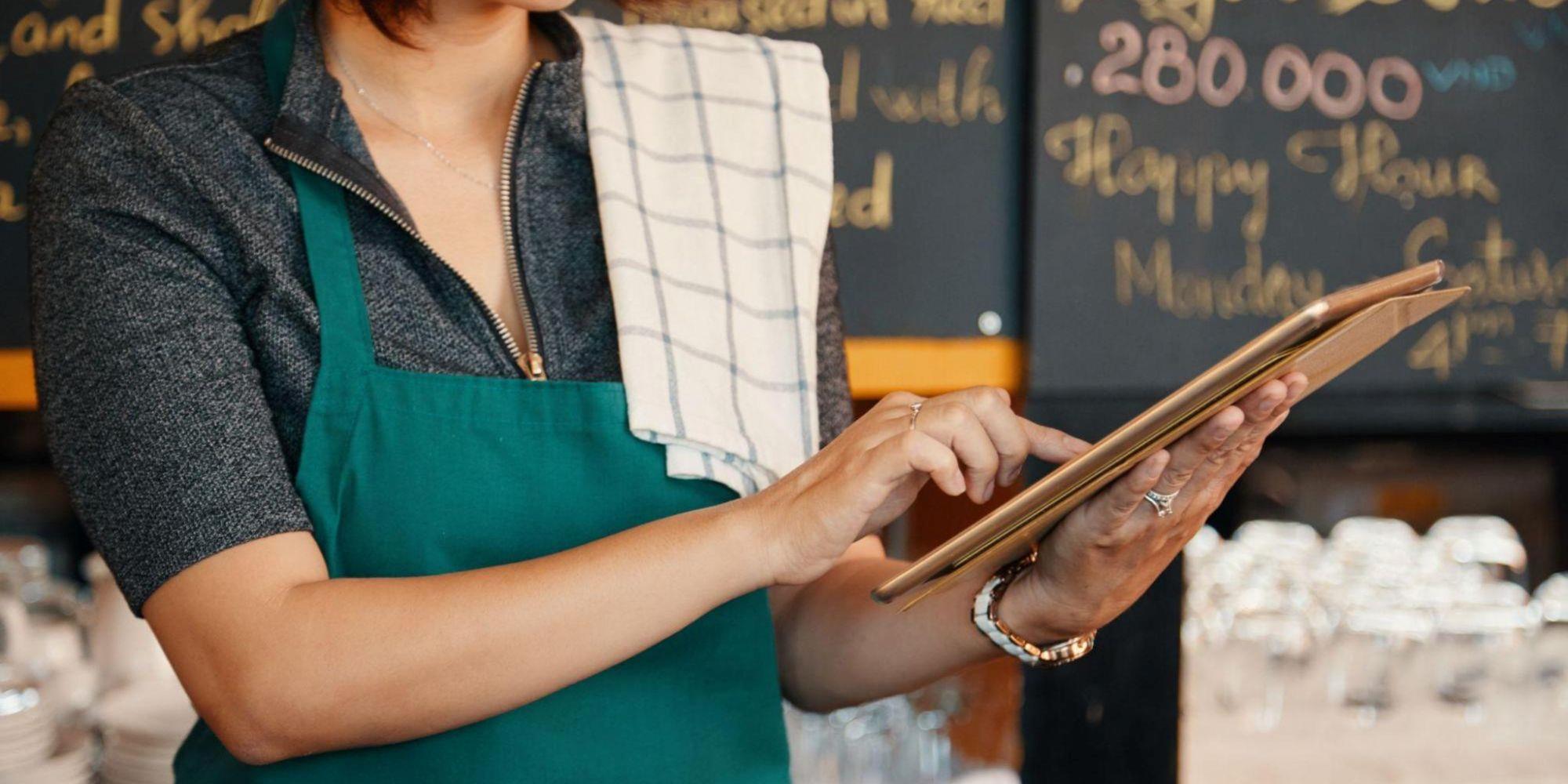 A small bakery staff using tablet digital signage.