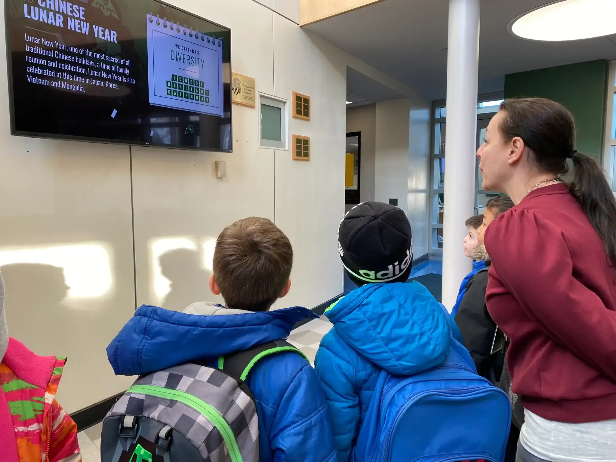 Two students in front of a display with a teacher